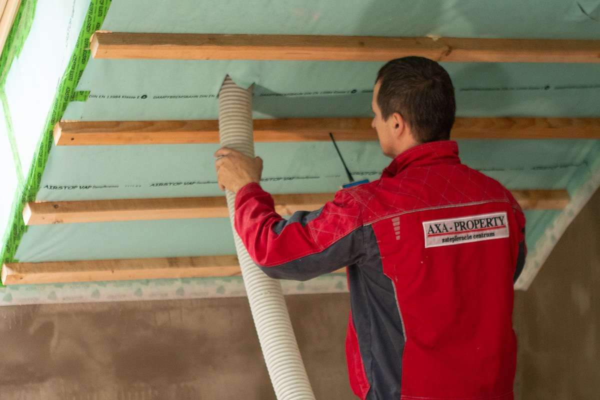 Odborník z Axa Property aplikuje fúkanú izoláciu